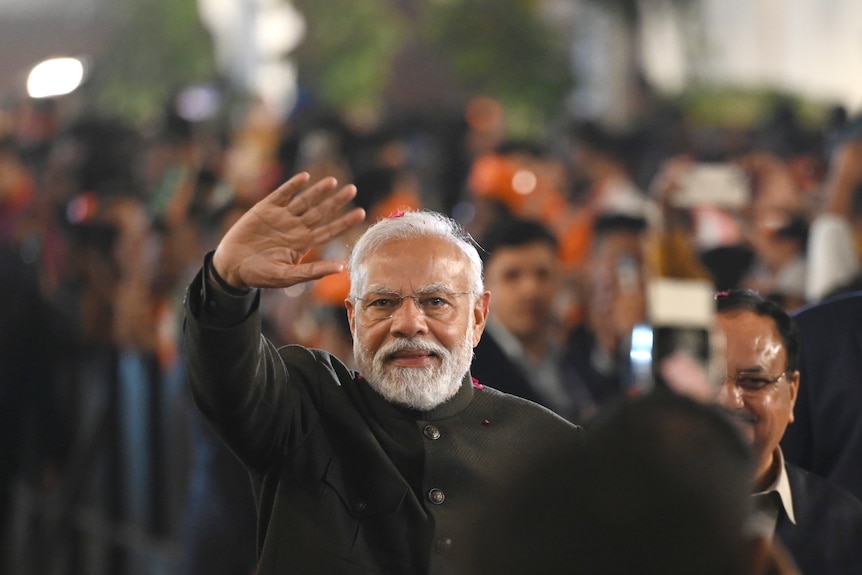Indian Prime Minister, Narendra Modi, waving at the camera.