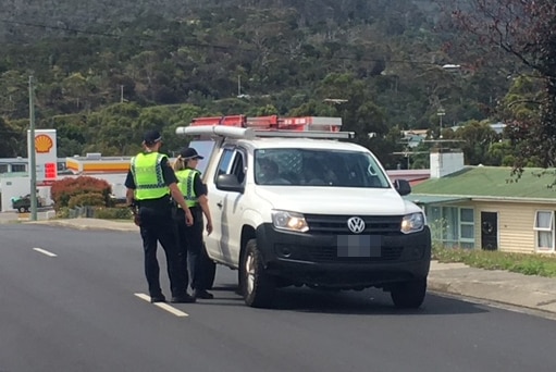 Tasmania Police speak to a motorist during a manhunt in Risdon Vale, 23 December 2018.