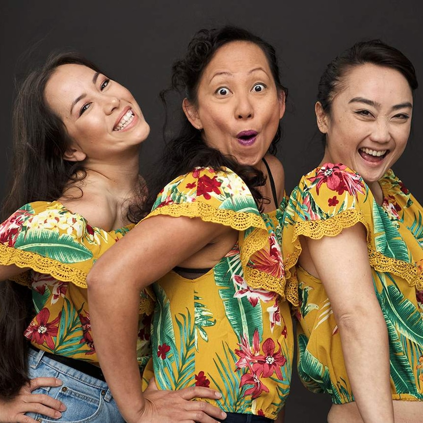 Courtney Stewart, Hsiao-Ling Tang and Jing-Xuan Chan wearing matching floral tops line up and smile at the camera.