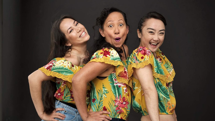 Courtney Stewart, Hsiao-Ling Tang and Jing-Xuan Chan wearing matching floral tops line up and smile at the camera.