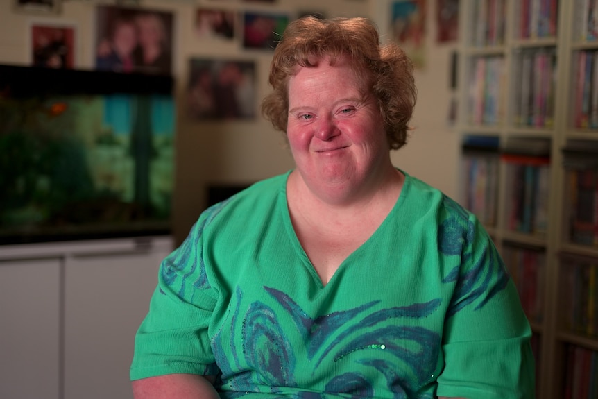 A woman with Down syndrome wearing a green top