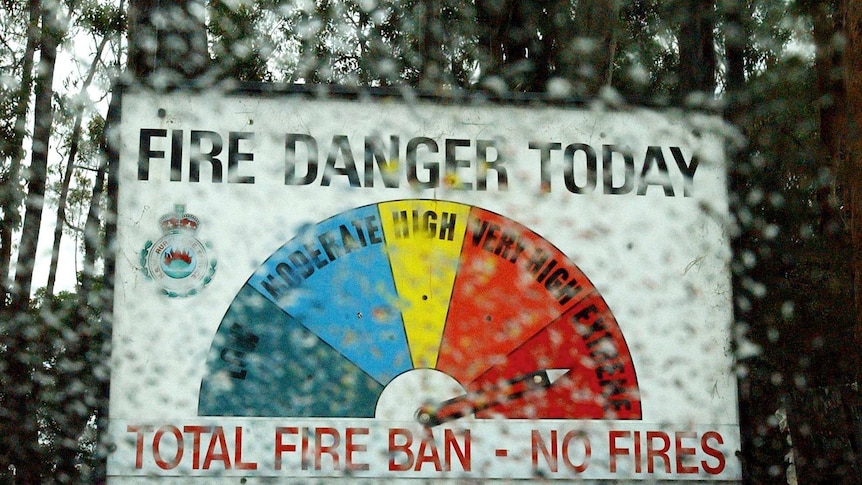 A view of a very high fire danger sign with rain splatters blurring the photo