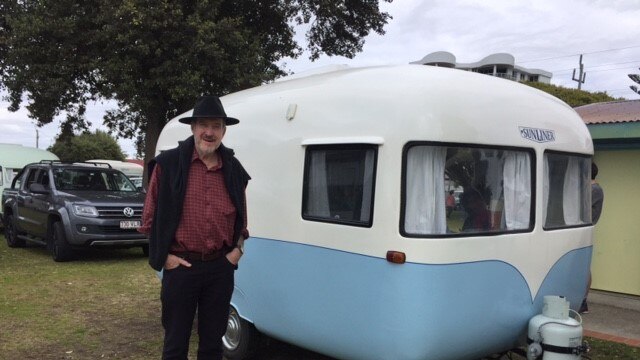 Robert Tickner, the son of the man who designed the Sunliner, standing in front of a Sunliner Caravan at the 60th anniversary