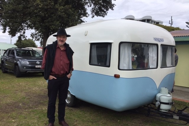 Robert Tickner, the son of the man who designed the Sunliner, standing in front of a Sunliner Caravan at the 60th anniversary