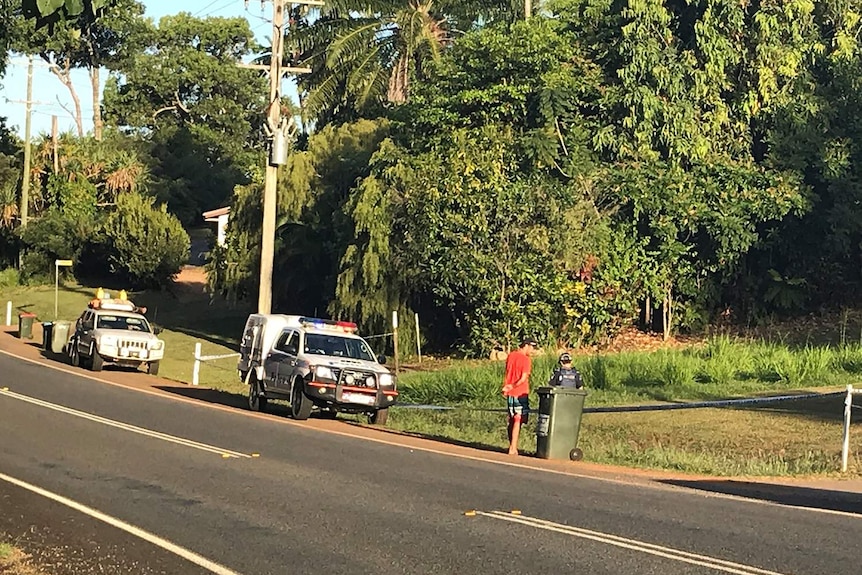 Police talk to people on a street where three skydivers have died in Mission Beach, far north Queensland.