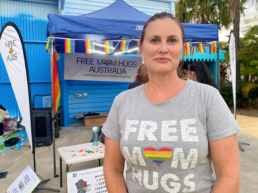 Woman standing with a free mum hugs t-shirt, not smiling