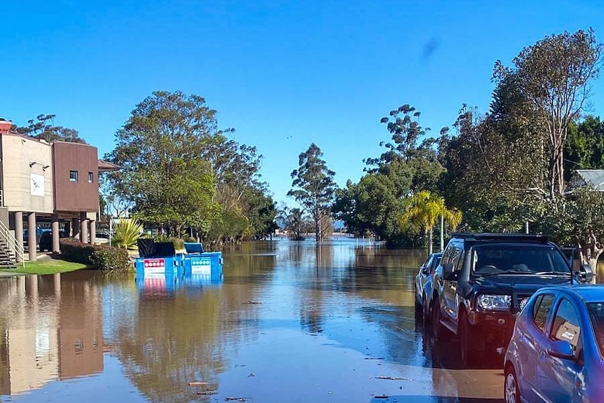 A flooded street with cars parked