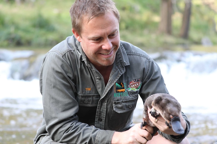 A man holding a platypus.