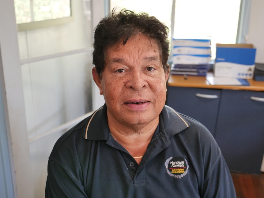 A middle-aged Aboriginal man looks directly into the camera.