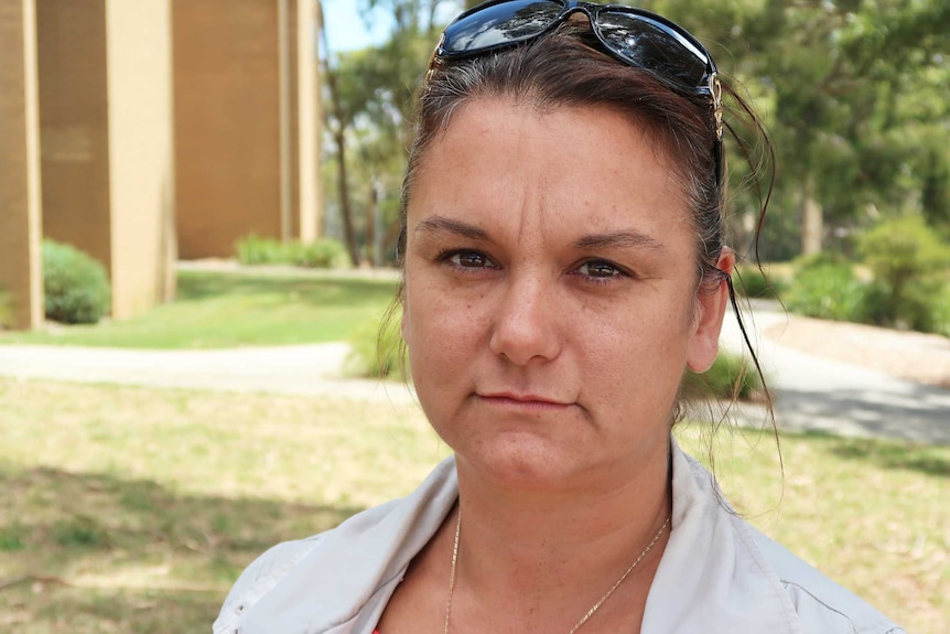 Katrina Beer stands outside wearing her sunglasses on top of her head.