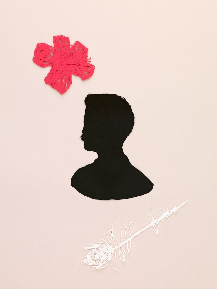 A paper cut out of a man's silhouette, a flower and pea cock feather