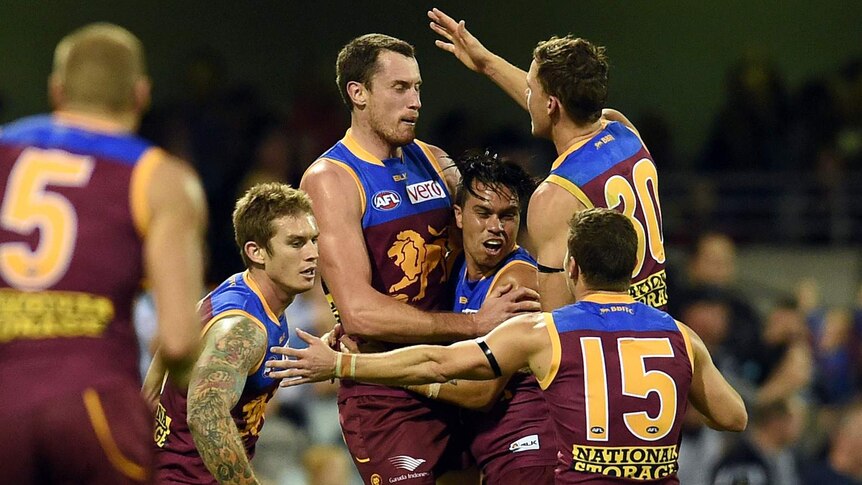 Brisbane's Matthew Leuenberger celebrates with team-mates after his goal against Port Adelaide.