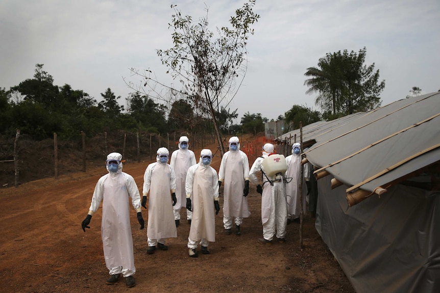 A burial team awaits decontamination in Liberia