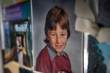 A photo of a child in school uniform attached to a fridge.