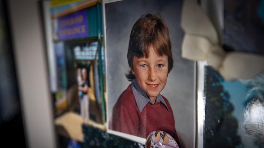 A photo of a child in school uniform attached to a fridge.