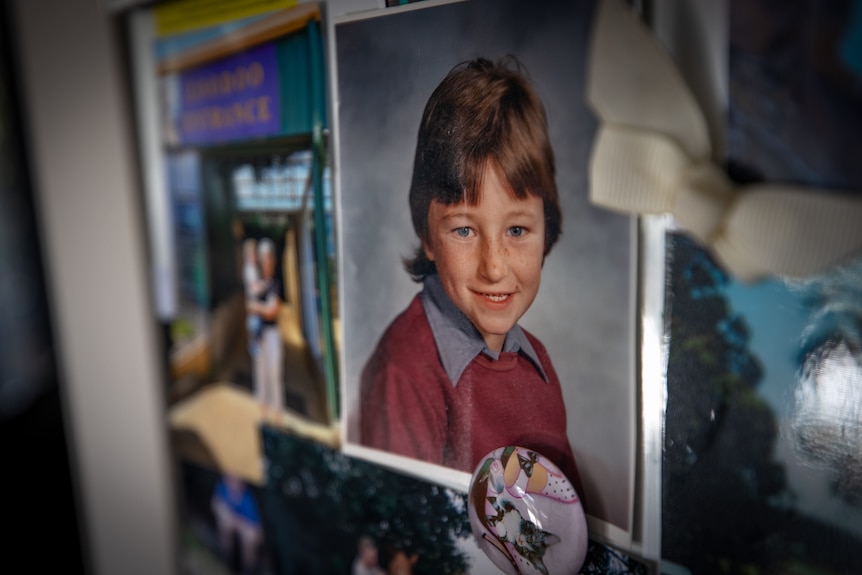 A photo of a child in school uniform attached to a fridge.