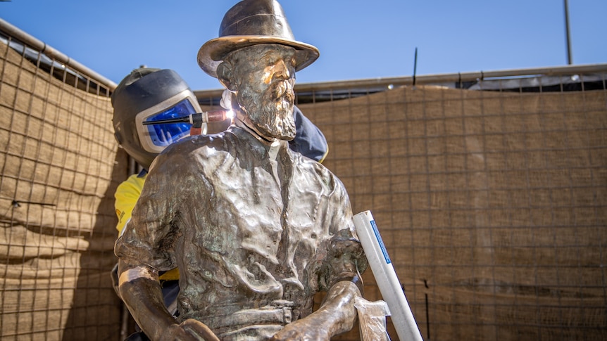 A welder working to repair a statue which was damaged by vandals.  