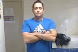 Man in a blue tshirt with arms crossed
