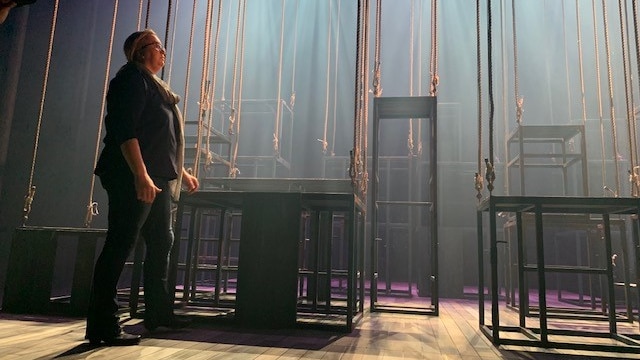 A woman standing amongst a stage set