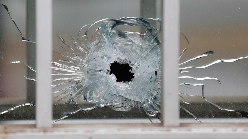 A bullet's impact is seen on a window at the scene after a shooting at the Paris offices of Charlie Hebdo