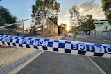 Police tape across Wellington Street in Perth at dawn.