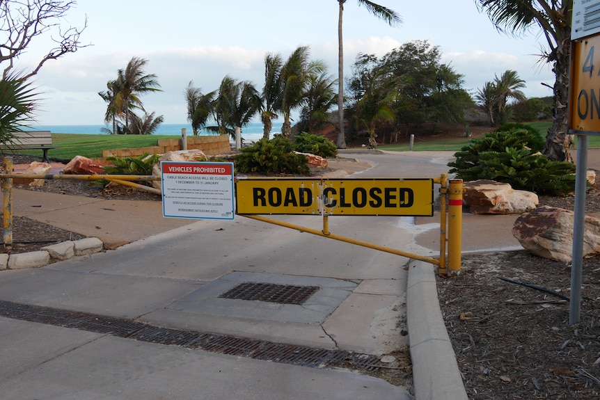 Yellow 'road closed' sign closing off ramp access to Broome's Cable Beach during turtle monitoring season. 