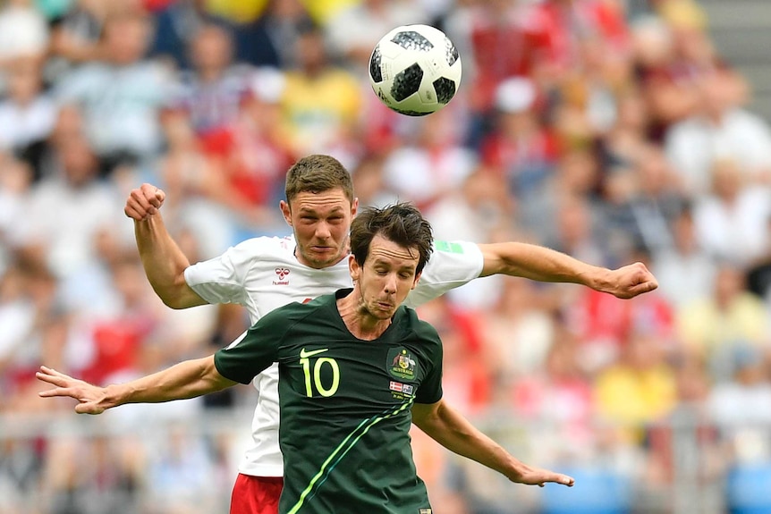 Australia forward Robbie Kruse goes for a header against Denmark