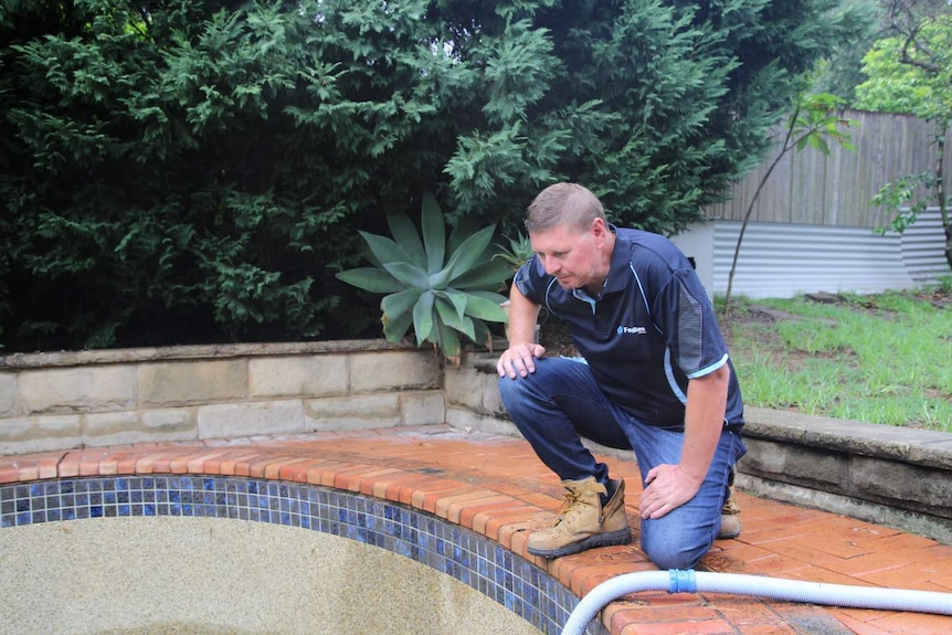 A man looks at a swimming pool