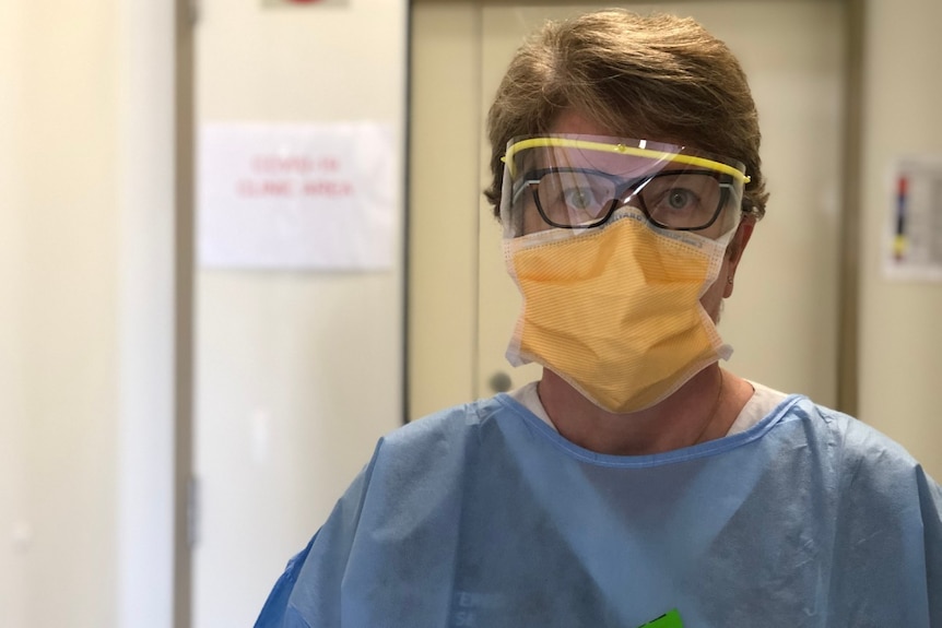 A healthcare worker wearing protective glasses and mask.