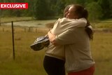 Two women hug in a field