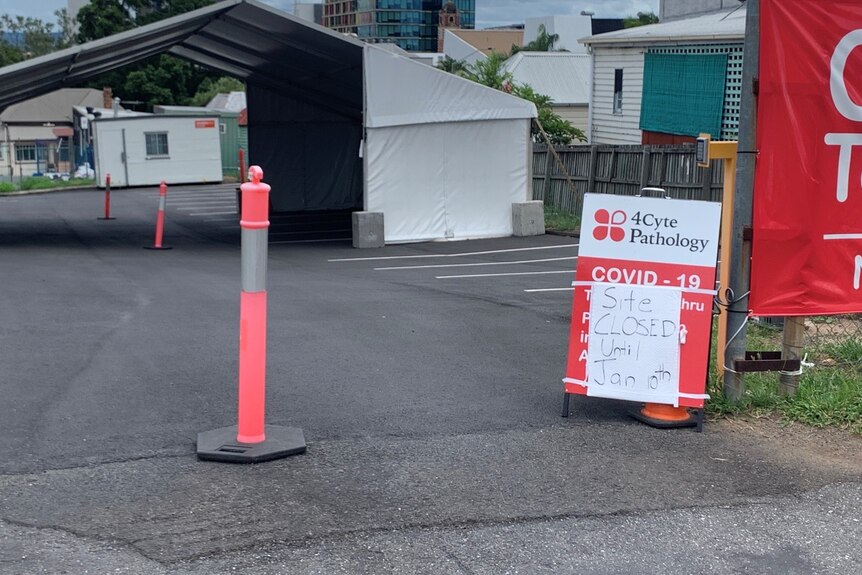 Signs showing closed and empty drive through COVID-19 testing clinic at Ipswich Central