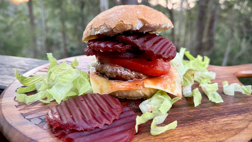 Sliced beetroot in front of a burger with beetroot on it.