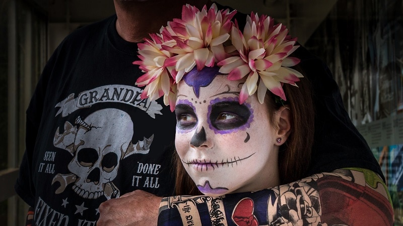 Girl will skull design painted on face and flowers on head