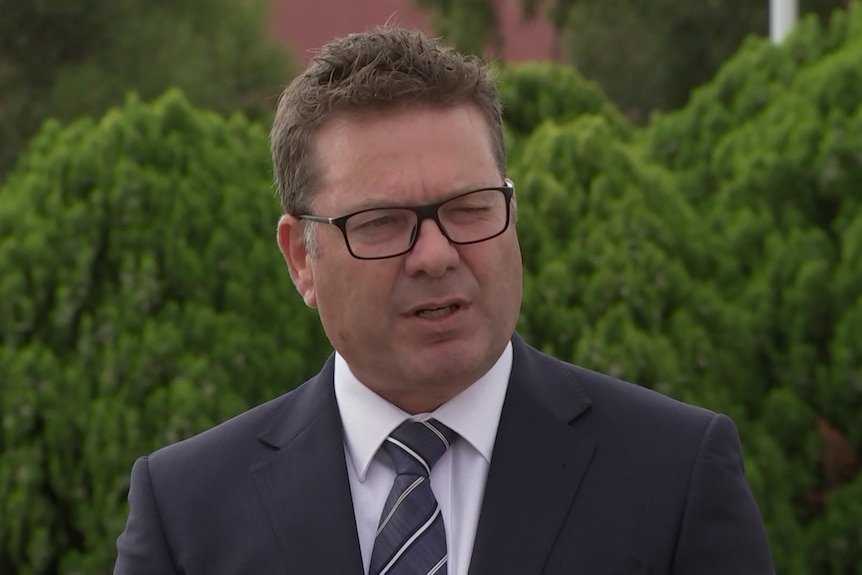 A man in a business suit and glasses