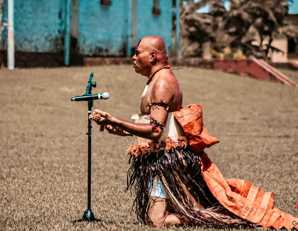 A man in traditional dress speaking making an offering 