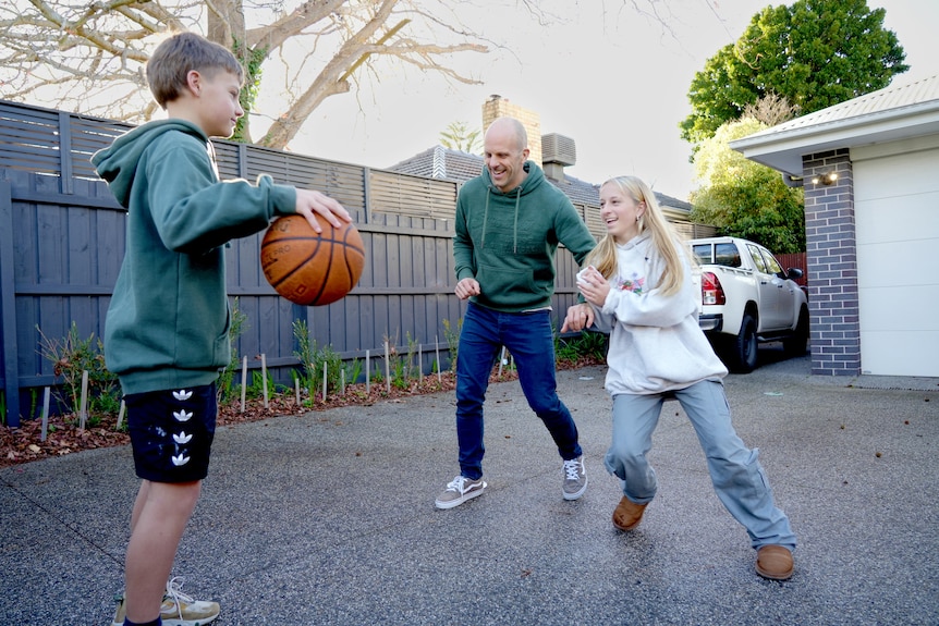 Tony plays basketball with his son and daughter.
