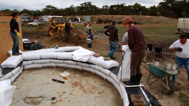 Volunteers lay down the first earth bags