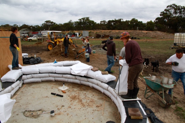 Volunteers lay down the first earth bags