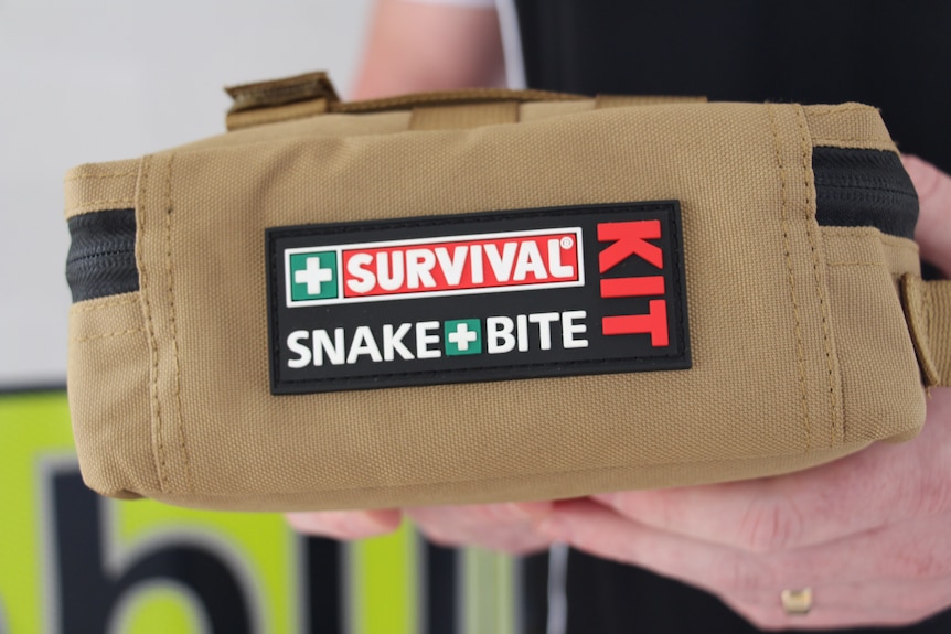 Someone holding a snake bite kit