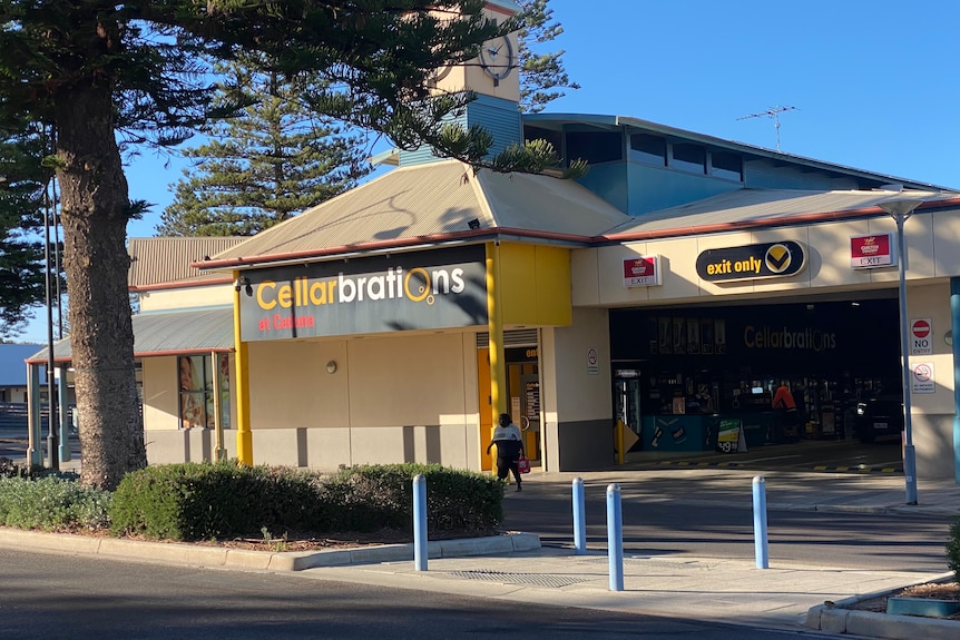 cellarbrations bottle shop in Ceduna with a woman holding beer out the front