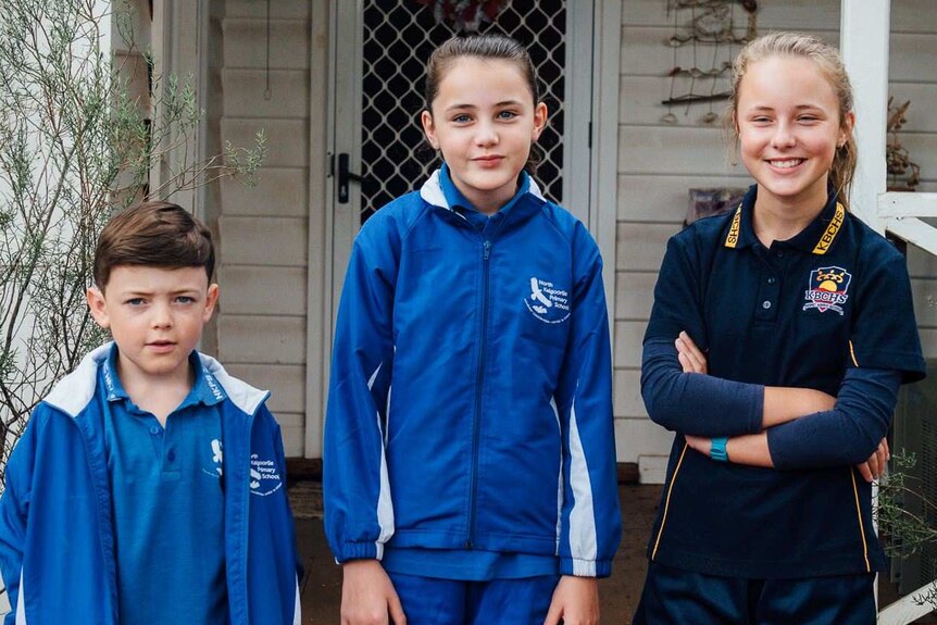 Carys Priest and her brother and sister, out the front of their home, on her first day of high school in 2017 in Kalgoorlie.