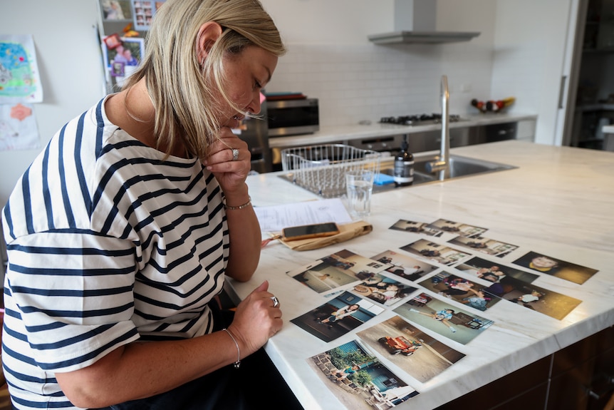 Angela Pucci Love looks at printed out photos of her and her sister Bridget