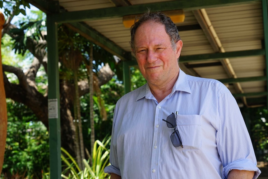 Robert Parker stands outside the hospital with a sombre expression.