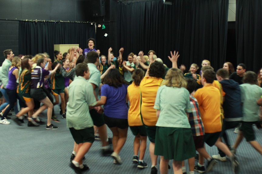 School students in a circle playing games during Sugarland workshop