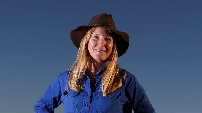 Woman standing in the outback with her hands on her hips