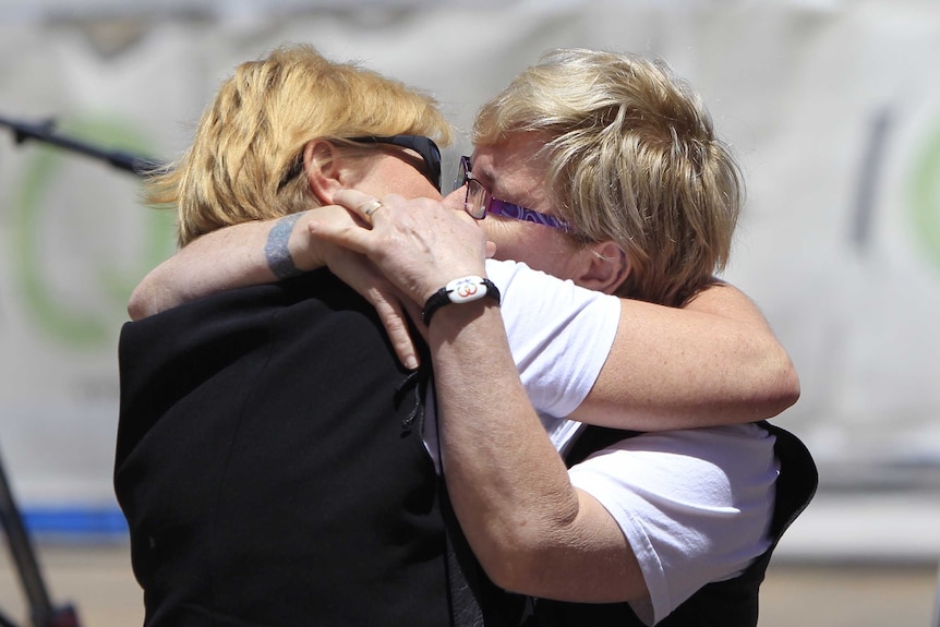 A couple kiss in front of the High Court of Australia