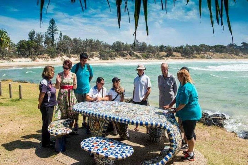 Tourists and Unkya Cultural Eco Tours guide on the headland above the ocean at Scotts Head, NSW.