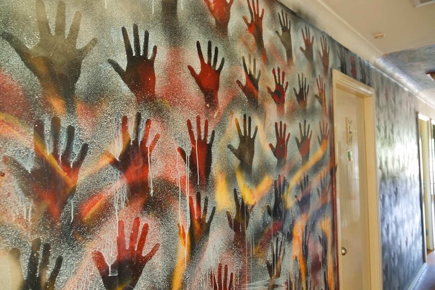 A wall of hands inside Weigelli rehab, signifying those who have gone through the program