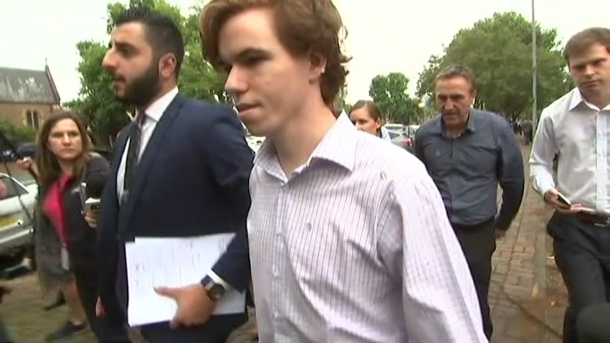 A young man walks towards court with his lawyer