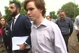 A young man walks towards court with his lawyer